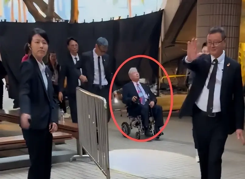 76岁洪金宝轮椅出行，10多名保镖护航，老婆抢尽风头