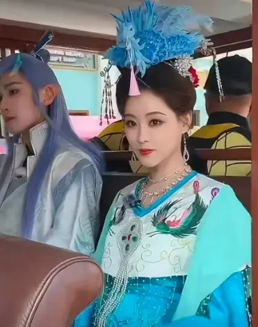 蓝绿裁衣映芳容，羽冠添艳衬清欢